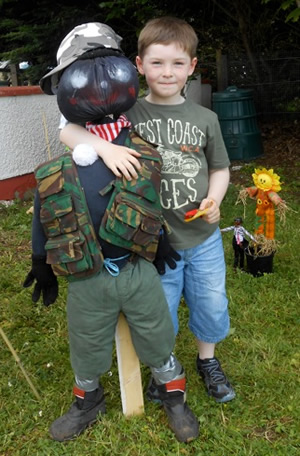 Pupil of St Aidans Ballintrillick School with his arm round his scarecrow