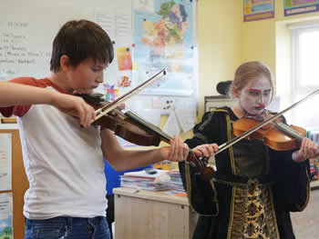 Boy & girl at St Aidans NS Ballintrillick playing fiddle