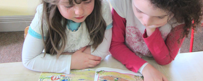 Senior pupil listening to junior pupil read at St.Aidans NS Ballintrillick