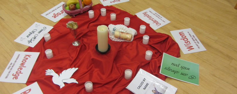 Red cloth with candles around and white paper angel
